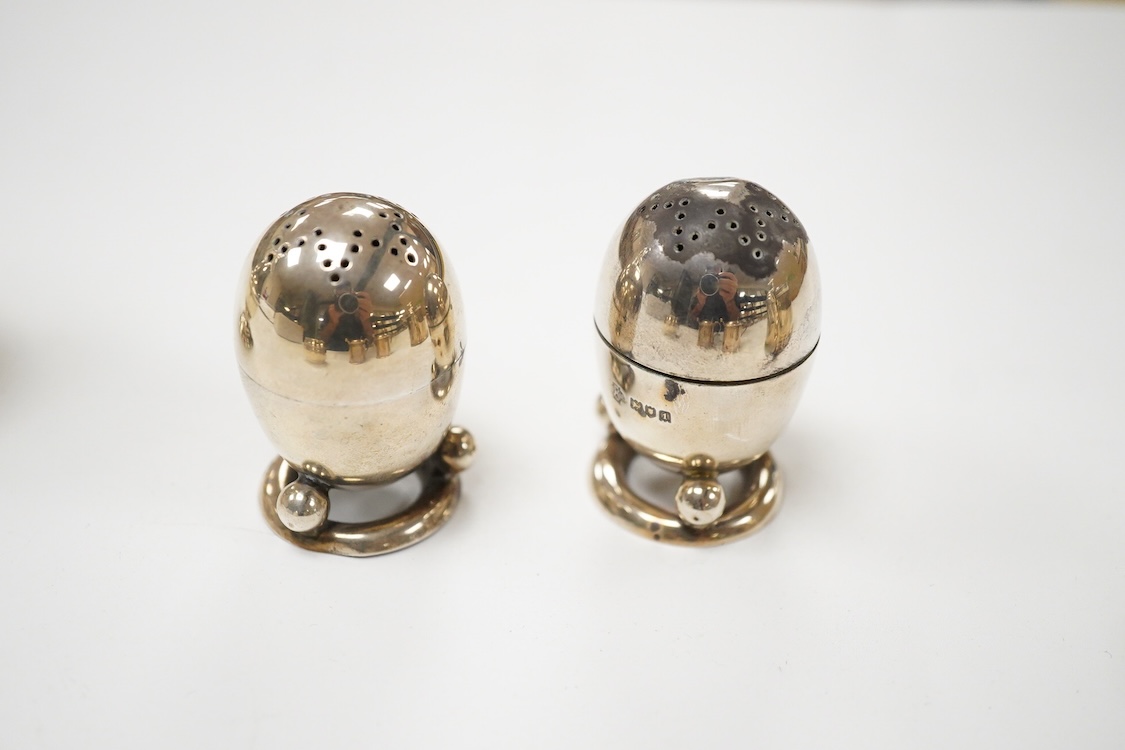 A George V silver mustard pot, London, 1931, with blue glass liner and associated silver shovel, together with a George V silver pepperette, a pair of small silver mustard pots and spoons, a pair of small silver pepperet